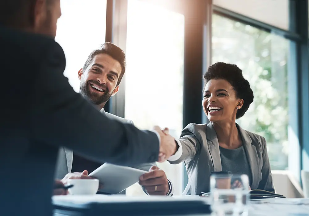 smiling woman shaking a mans hand